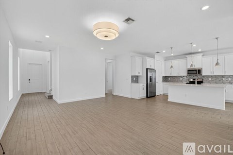 A spacious kitchen with white cabinets and a central island.