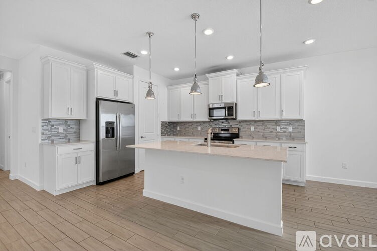 A kitchen with white cabinets and a wooden island.