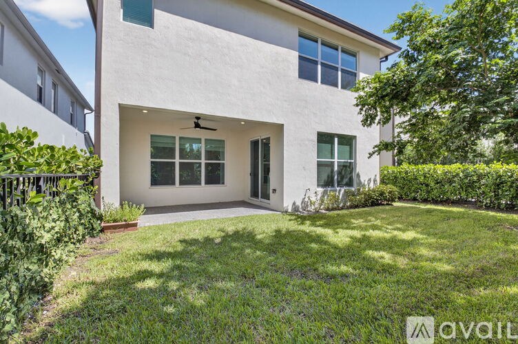 A white house with a green lawn in front.