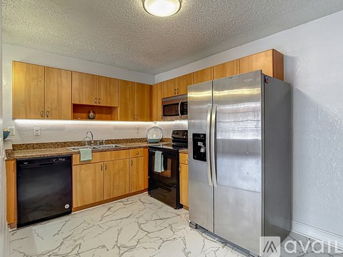 A kitchen with a black oven and a stainless steel refrigerator.