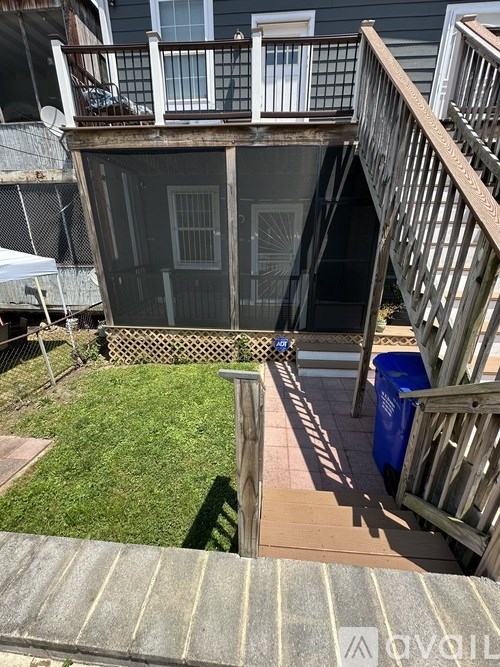 A small backyard with a deck and a small tree.