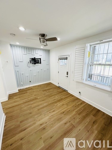 A room with wooden flooring and a ceiling fan.