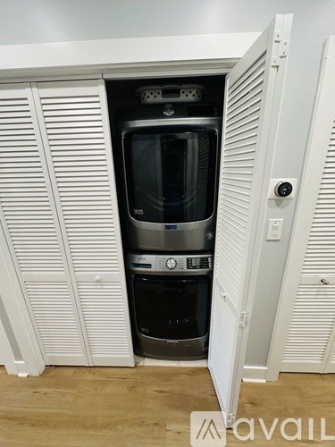 A white cabinet with a black appliance inside.