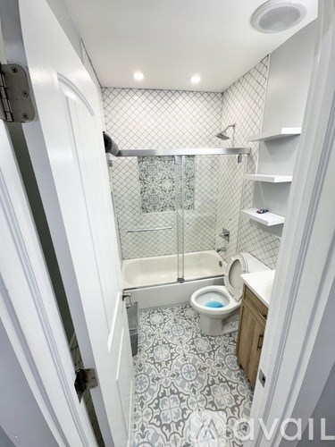 A small bathroom with a toilet and a walk-in shower.