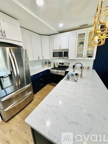A kitchen with a marble countertop and stainless steel appliances.