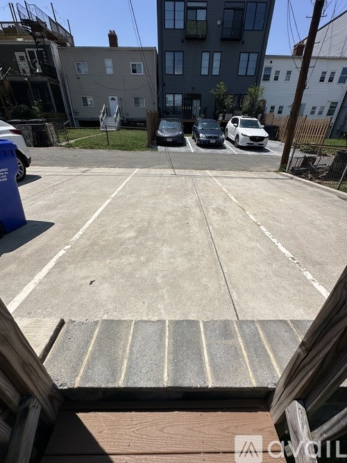 A parking lot with a white car and a blue car parked in it.