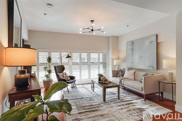 A well-lit living room with a sofa, armchair, and a coffee table.