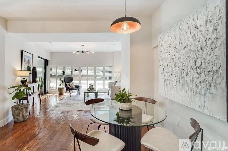 A modern dining room with a glass table and chairs.