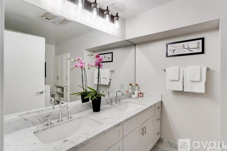 A bathroom with a sink, mirror, and towel rack.