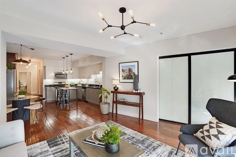 A modern living room with a kitchen in the background.
