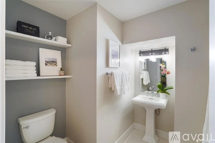 A bathroom with a white toilet and a white pedestal sink.