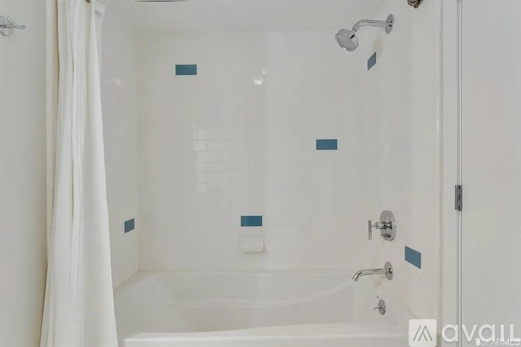 A white bathroom with a white tub and a white shower curtain.