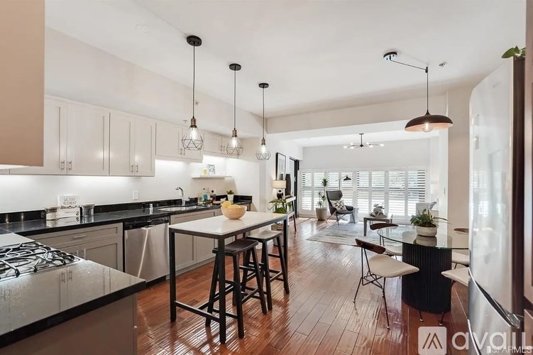 A modern kitchen with a black stove top oven and a white island.