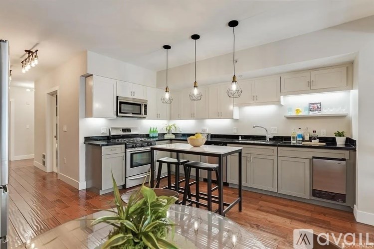 A modern kitchen with a center island and pendant lights.