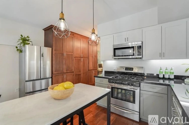 A kitchen with a white table and a bowl of lemons on it.