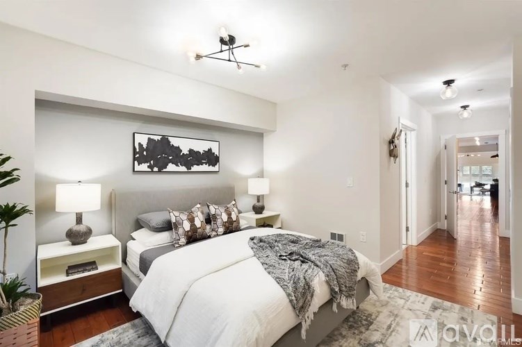 A bedroom with a large bed and a painting on the wall.