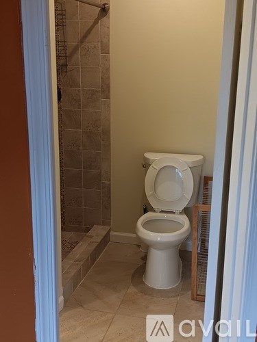 A white toilet in a bathroom with tiled walls.