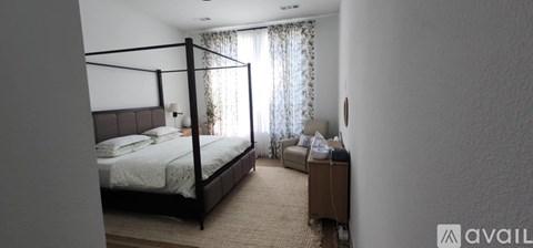 A bedroom with a large bed and a smaller bed in the corner.
