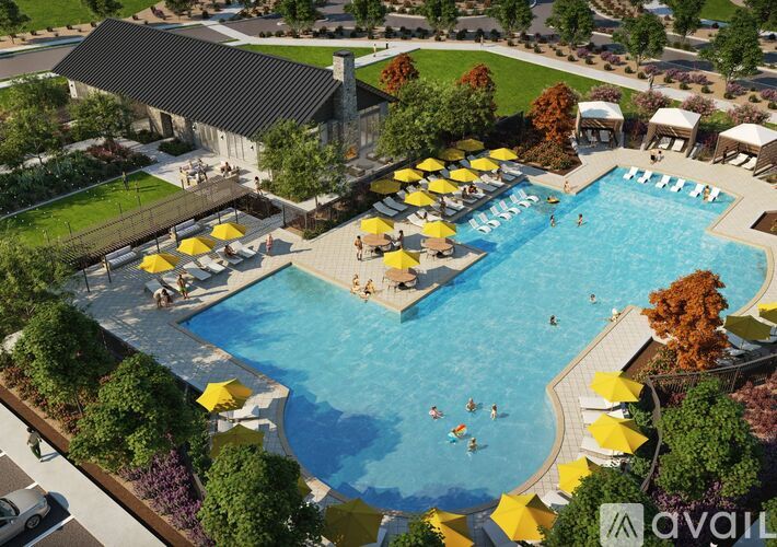 A large outdoor swimming pool surrounded by yellow umbrellas and people enjoying the water.