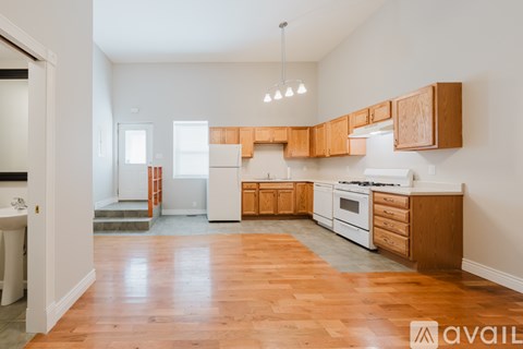 A kitchen with wooden cabinets and a white fridge.