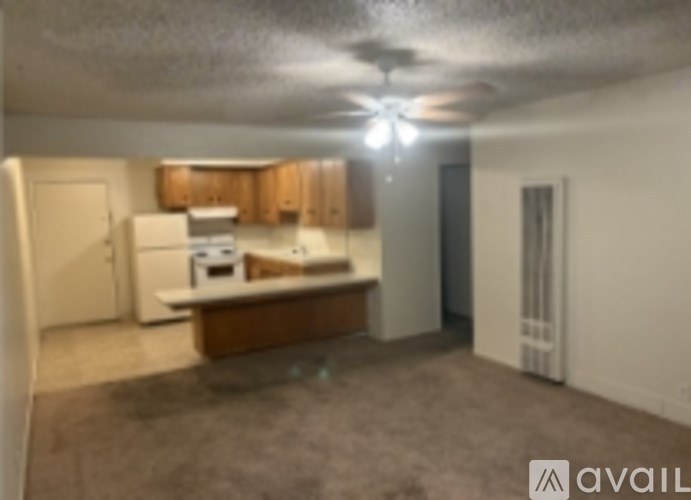 A kitchen area with a refrigerator, sink, and cabinets.