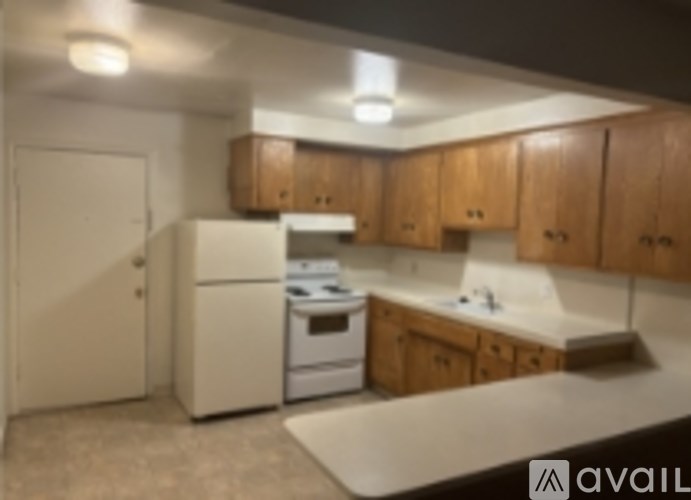 A kitchen with wooden cabinets and a white fridge.