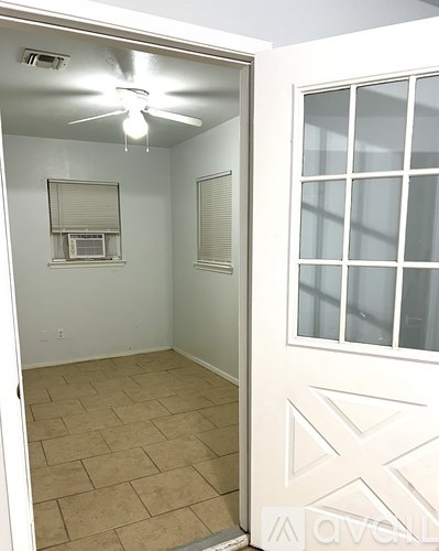 A room with a ceiling fan and a window with blinds.