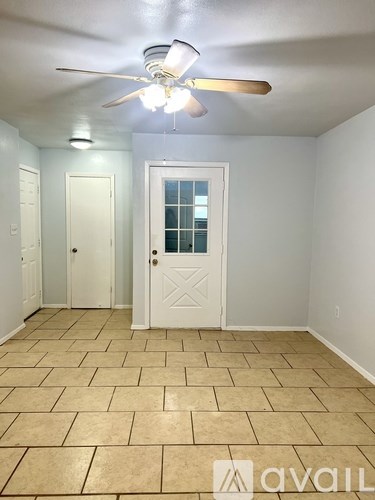 A room with a ceiling fan and tile flooring.