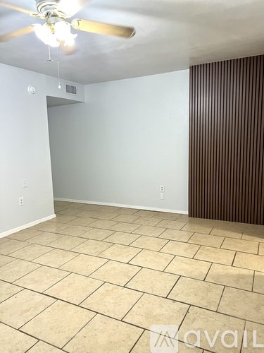 A room with a ceiling fan and tiled flooring.