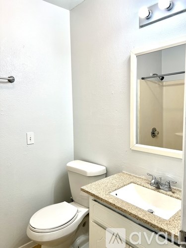 A white toilet sits next to a sink in a bathroom.