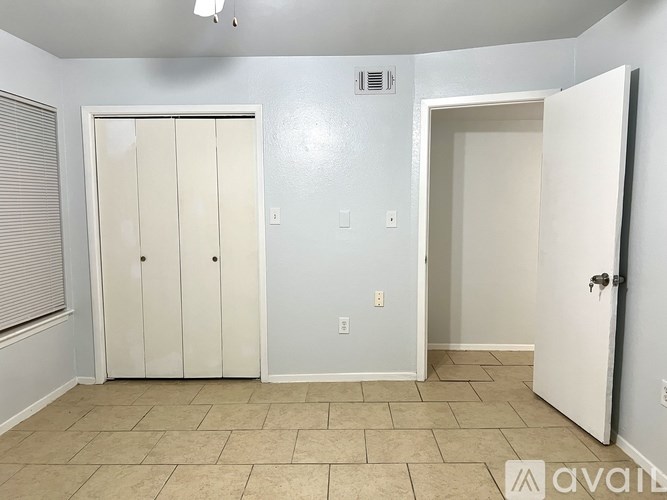 A room with two doors and a tiled floor.