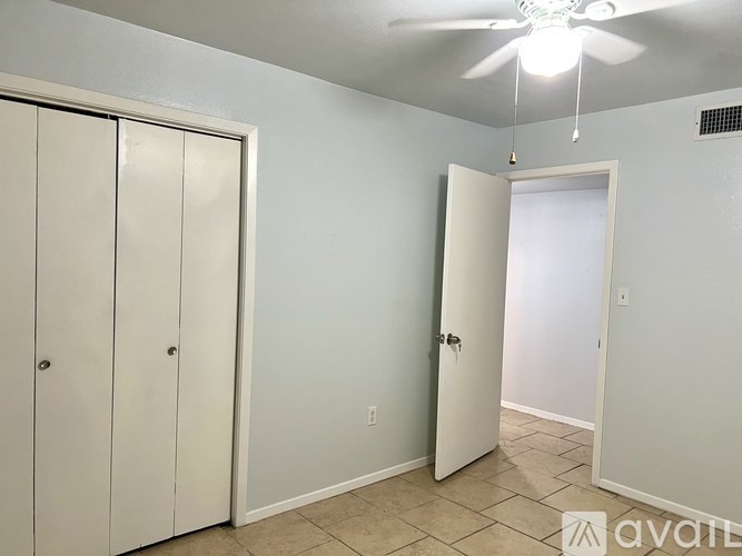 A room with a ceiling fan and two doors.