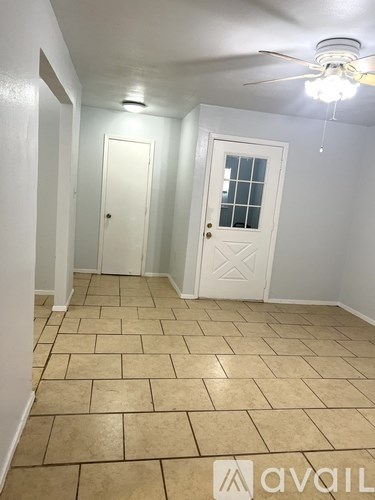 A room with a tiled floor and two white doors.