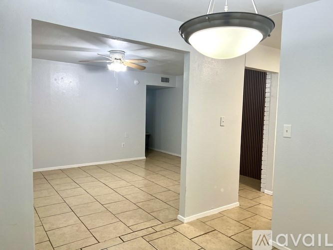 A spacious room with a ceiling fan and a light fixture.