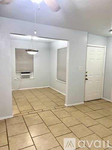 A room with tiled flooring and a hanging light fixture.