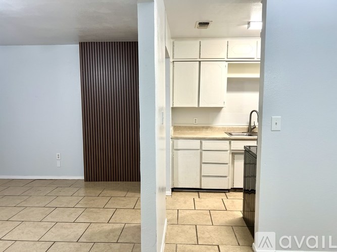 A kitchen with white cabinets and a tiled floor.