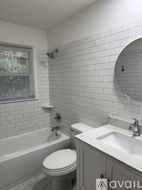 A white bathroom with a toilet, sink, and tub.