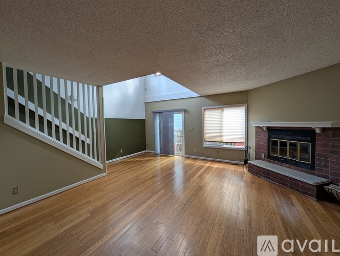 A living room with wood flooring and a fireplace.