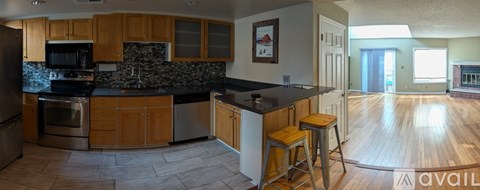 A kitchen with wooden cabinets and a black countertop.