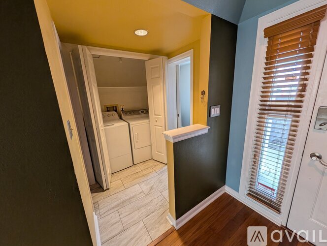 A small bedroom with a washer and dryer in it.
