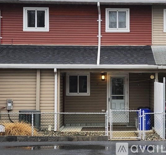 A red house with a white door and a white fence.