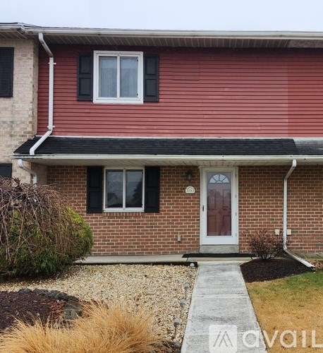 A red house with a white door and black shutters.