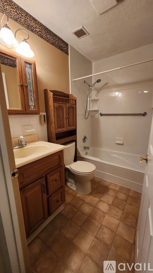 A bathroom with brown tiles and a white sink.