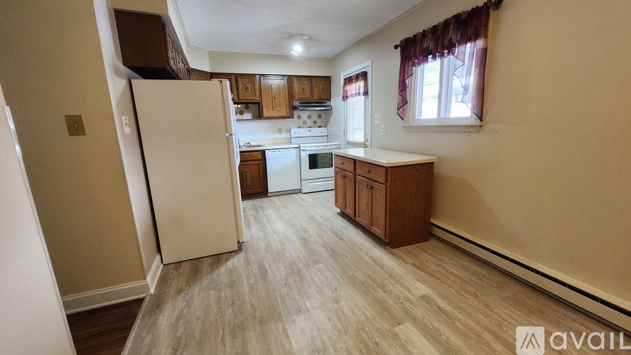 A kitchen with wooden cabinets and a white refrigerator.