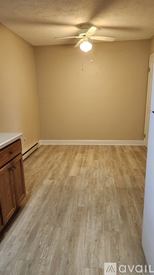A room with wooden flooring and a ceiling fan.