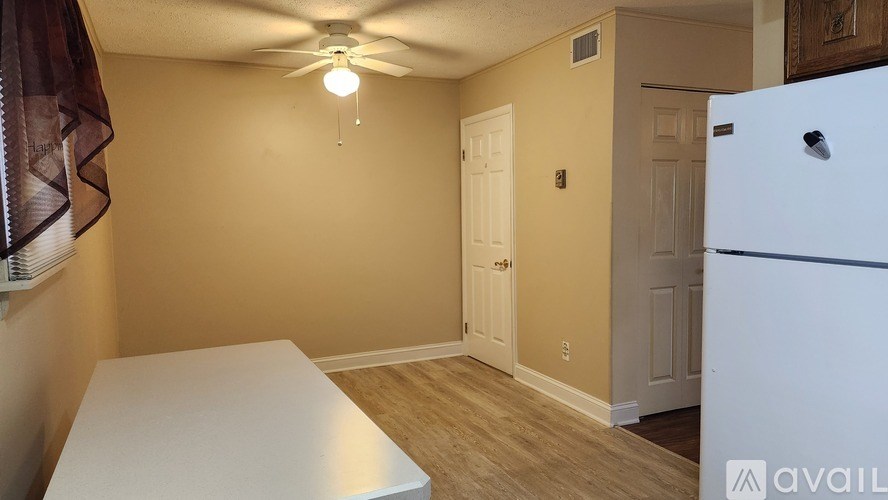 A kitchen area with a white fridge and a table.