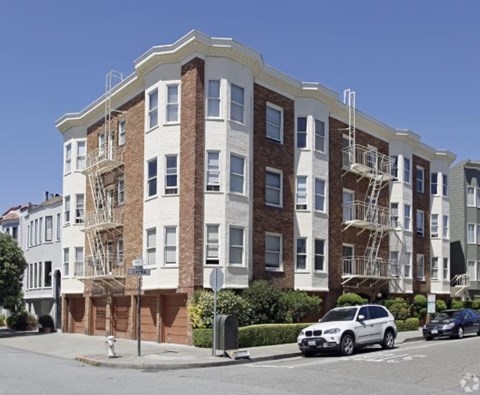 A white and brown building with fire escapes on the side.