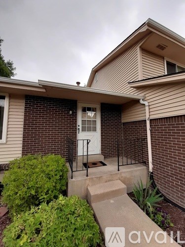 A house with a white door and a brick wall.
