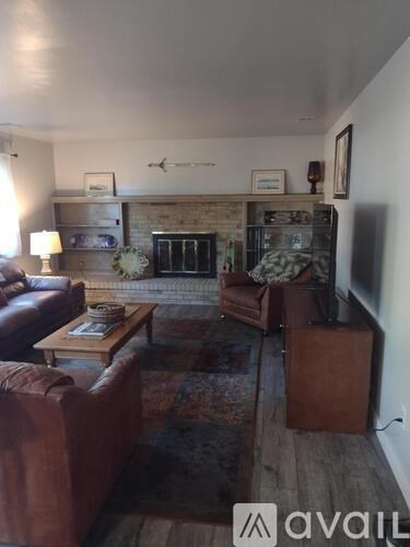 A living room with a brown leather couch and a wooden coffee table.