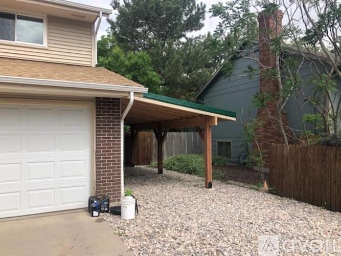 A house with a white garage door and a gravel driveway.